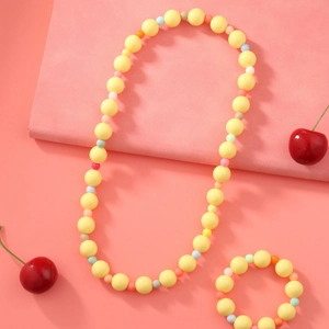 Ensemble bijoux enfant avec perles acryliques jaunes et collier cœur coloré