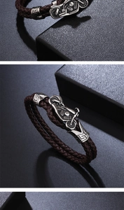 Close-up of brown braided leather bracelet with vintage silver motorcycle charm buckle