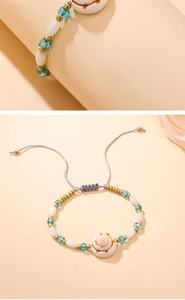 Dettaglio del bracciale bohemian con conchiglia, perle blu e cordino intrecciato
