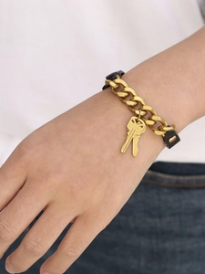 Detail van een gotische lederen beenring met gouden metalen kettingen en sleutelhangers