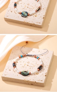 Détail du bracelet en nacre d'abalone avec perles turquoise et cordon en cuir ciré