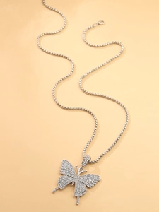 Detalle de un colgante de mariposa plateado con diamantes de imitación en cadena de bolas