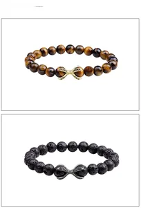 Detailed view of tiger eye and volcanic rock beaded bracelets with metal charms