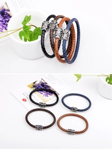 Close-up of four colors braided leather bracelets with embossed vintage metal charms