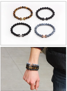 Detail of four-piece beaded bracelet set with infinity charms and natural lava stones