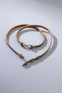 Detail of genuine brown leather belt with vintage bronze infinity buckle and adjustable snaps