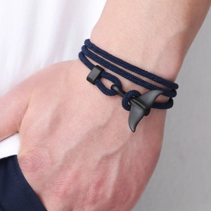 Navy braided multi-layer rope bracelet with black whale tail charm on wrist
