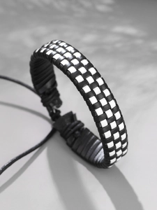 Détail du bracelet en cuir tressé à damier noir et blanc avec cordon de serrage réglable