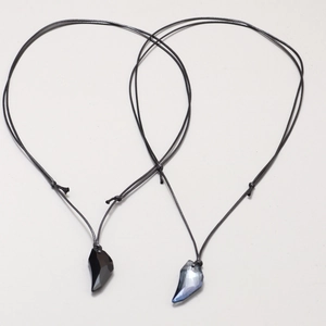 Wolf tooth crystal pendant necklaces for couples in black and iridescent blue with cord chains