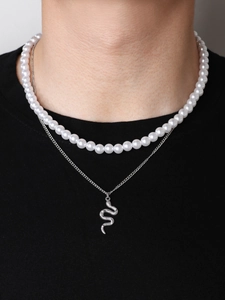 Close-up of double-layer necklace with white pearls and detailed silver snake pendant