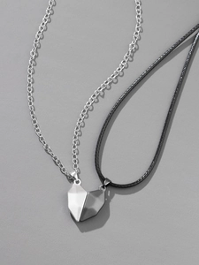 Close-up of magnetic heart-shaped pendant set with silver chain and black wax rope