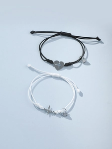 Détail de bracelets de couple ajustables avec cœur magnétique et cordon ciré tressé