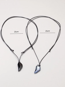 Detail view of 25cm wolf tooth couple necklaces with heart puzzle geometric pendants