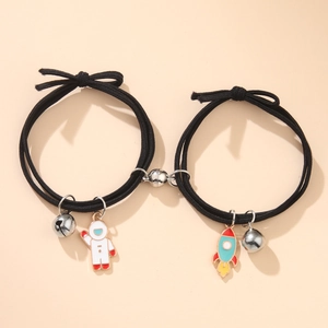 Magnetic astronaut couple bracelets with enamel rocket pendants and metal bells in black