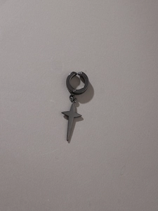 Close-up of black matte stainless steel huggie earring with four-pointed star pendant
