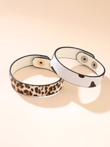 Detail of leopard and cow print faux leather bracelets with adjustable dual metal snaps