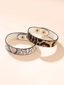 Detail of leopard and snake print leather bracelets with gold and silver snap buttons