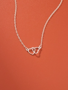 Detail of silver interlocking double heart pendant on a stylish textured red background