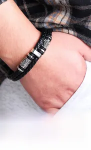 Détail d'un bracelet Viking en cuir noir tressé double couche avec des breloques argentées