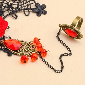 Macro shot of Gothic black lace bracelet with red rose and bronze ring chain detail