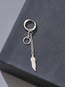 Detailed close-up of a silver stainless steel hoop earring featuring a delicate feather charm