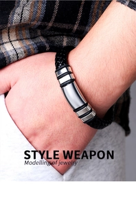 Close-up of a men's braided black leather bracelet with polished stainless steel details