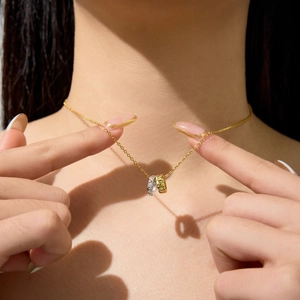 Close-up of dual-tone interlocking rings necklace with sparkling crystals on female model