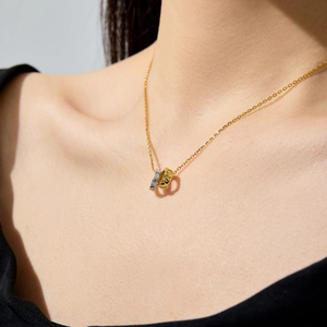 Detail shot of interlaced S925 silver rings on neck with diamond and textured gold finish