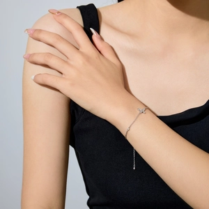 Close-up of S925 sterling silver bracelet with pavé butterfly charm on a wrist