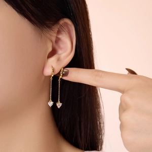 Elegant S925 silver gold-plated heart drop earrings with dangling zircon tassels on model