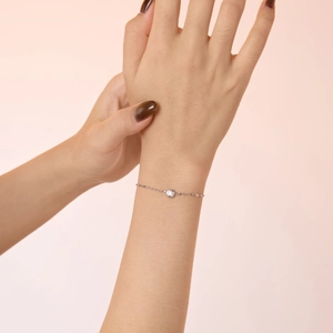 Detailed close-up of a delicate S925 sterling silver chain bracelet with a bezel-set diamond