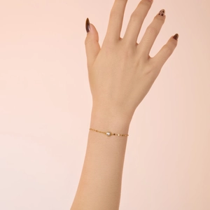 Detailed view of a minimalist S925 silver bracelet with a bezel-set diamond in gold finish