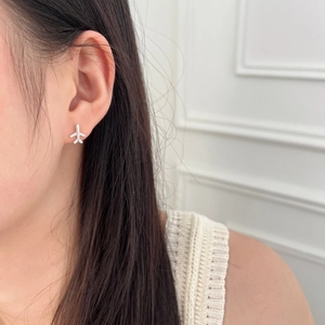 Close-up of S925 sterling silver airplane stud earrings with zircons on model ear