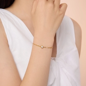 Close-up of a delicate gold S925 sterling silver bracelet with a single bezel-set diamond