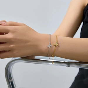 Detailed view of silver and gold chain bracelets featuring pave butterfly charms and zircon