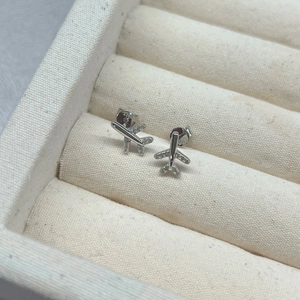 Macro view of S925 sterling silver airplane stud earrings with white zircon stones