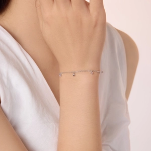 Détail du bracelet cœur en argent S925 avec pierres roses sur un poignet