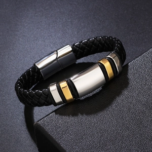 Men's braided leather bracelet with silver and gold metal accents on a gift box