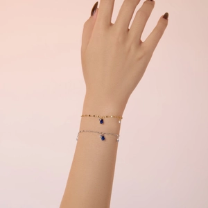 Elegant S925 sterling silver bracelets with blue teardrop pendants on female wrist