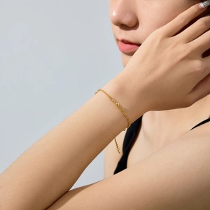 Close-up of gold beaded chain bracelet featuring adjustable links and polished finish