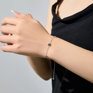 Close-up of a delicate S925 sterling silver butterfly charm bracelet on a wrist