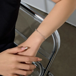 Detail of delicate S925 sterling silver beaded chain bracelet on a female wrist