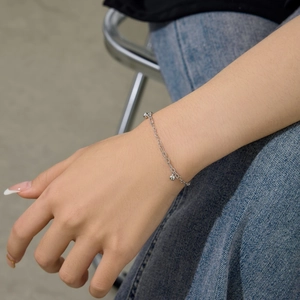 Close-up of S925 sterling silver chain bracelet with round bead pendant on female wrist