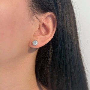 Close-up of a model wearing a 0.5ct halo Moissanite stud earring in S925 silver