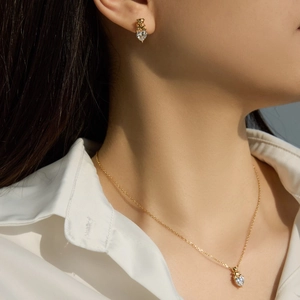 Gros plan d'un ensemble collier et boucles d'oreilles ours et cœur porté par un modèle
