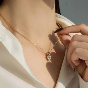 Gros plan d'un pendentif cœur en cristal sur chaîne dorée avec ombre de cœur créative