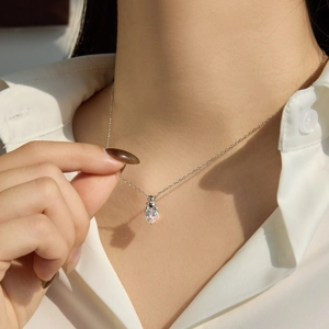 Détail d'un collier en argent S925 avec une pierre en forme de cœur et pendentif ours