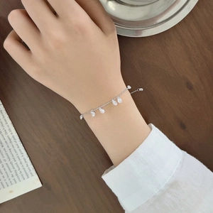 Detailed view of an S925 sterling silver bracelet featuring teardrop charms and fine link chain