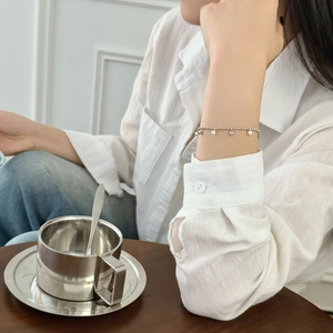 Détail du bracelet en argent S925 avec perles et pendentif coeur sur le poignet