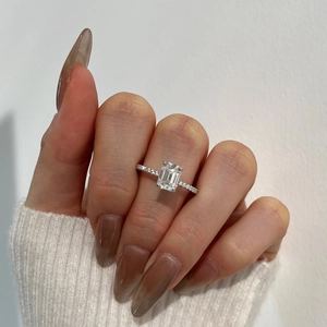 Detailed view of emerald cut gemstone ring with micro-pave sterling silver band on hand
